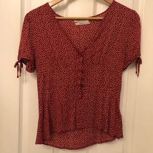 Red top with off white flowers. Size small.